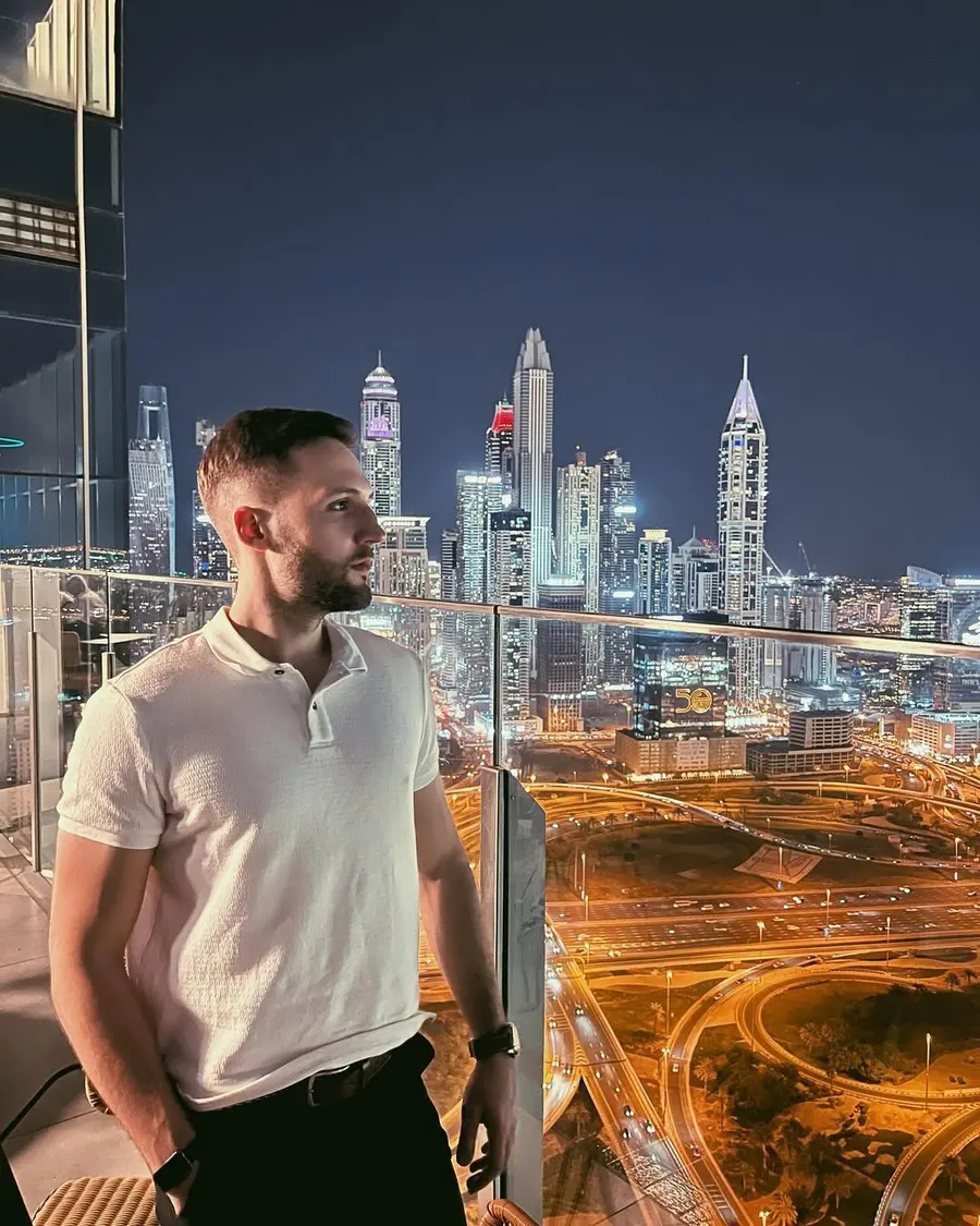 Marc Diez on a terrace in Dubai at night, with the city skyline behind him